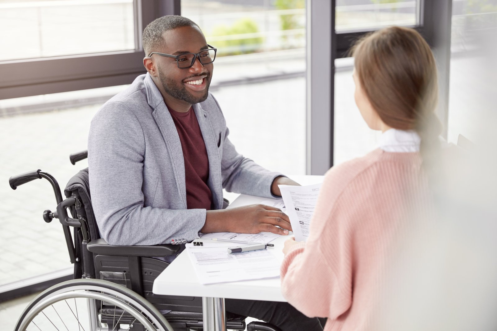 employee in wheelchair talking to coworker