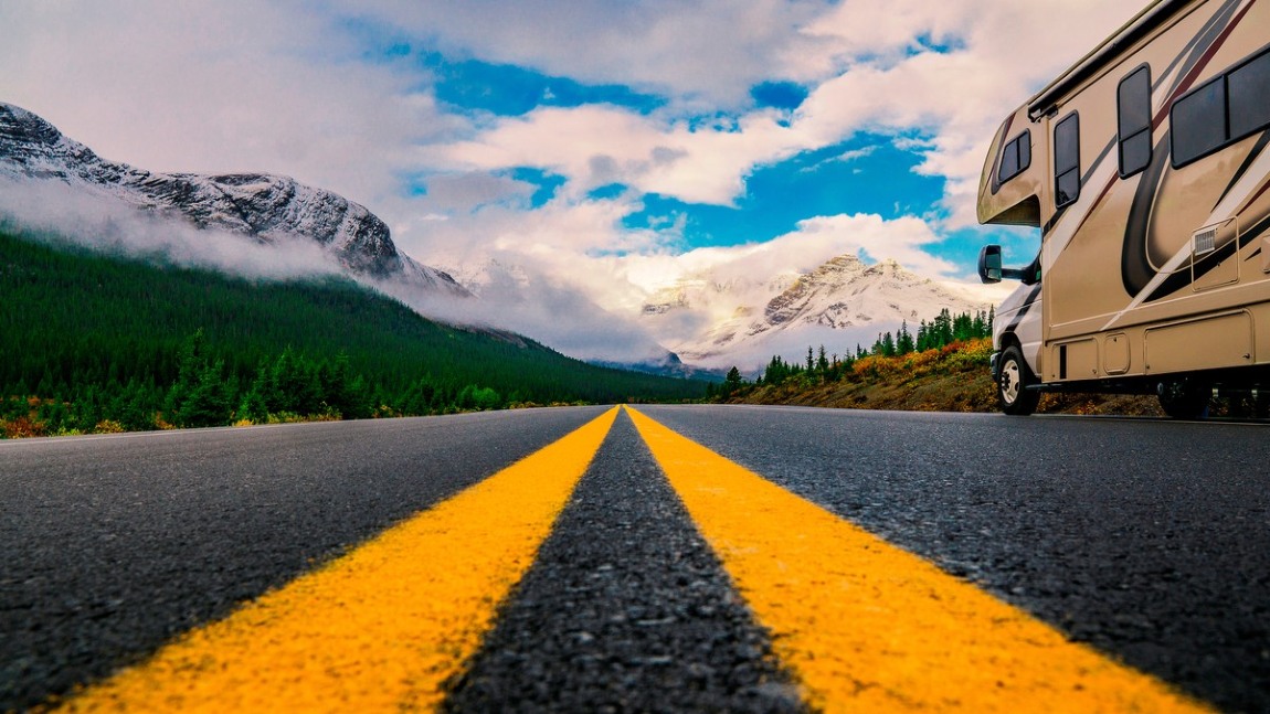 yellow lines on road with rv driving away