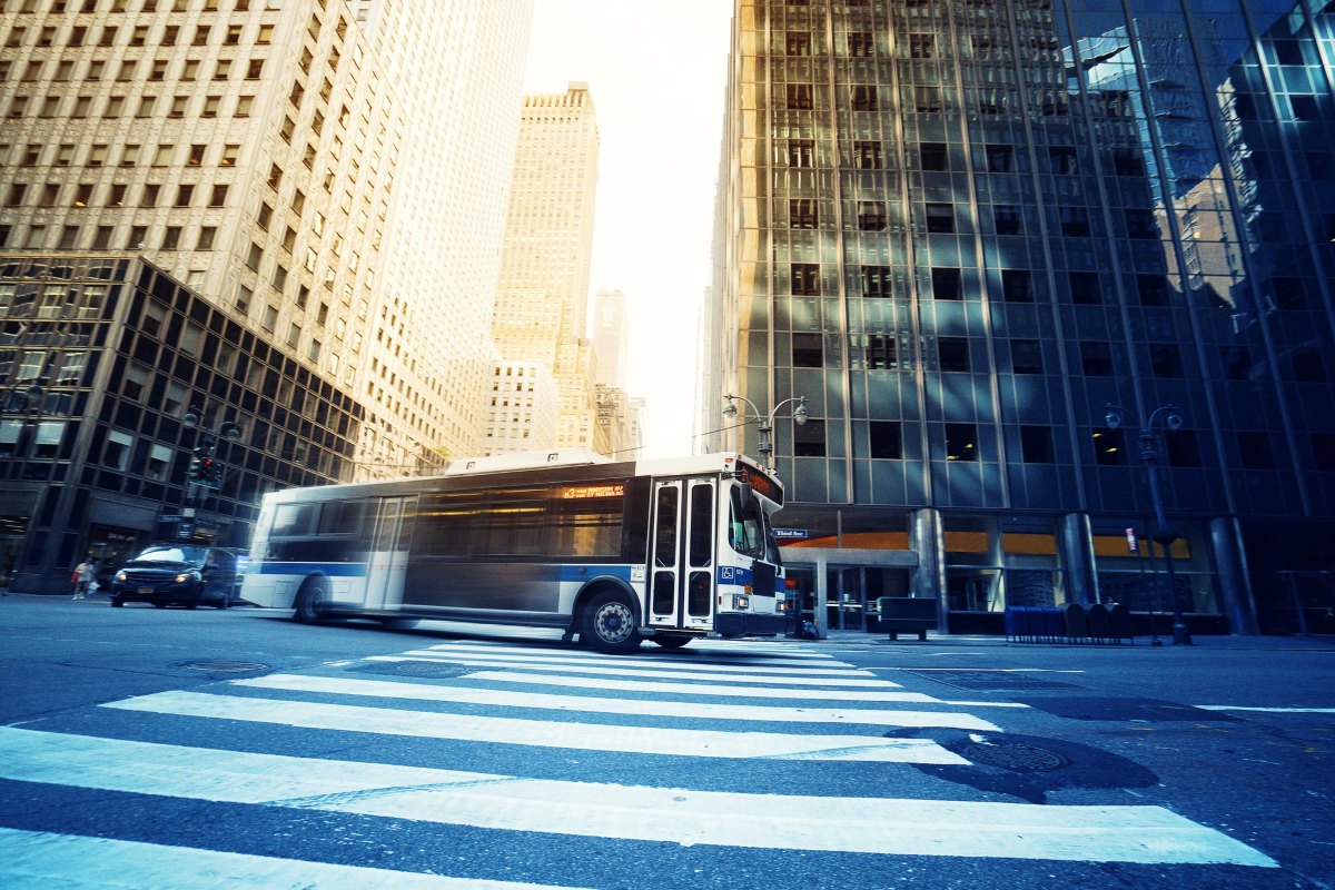 bus driving through intersection in large city