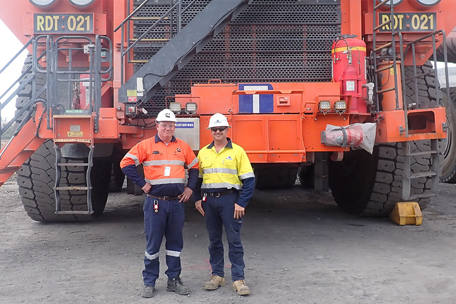 Employees standing in front of mining applications