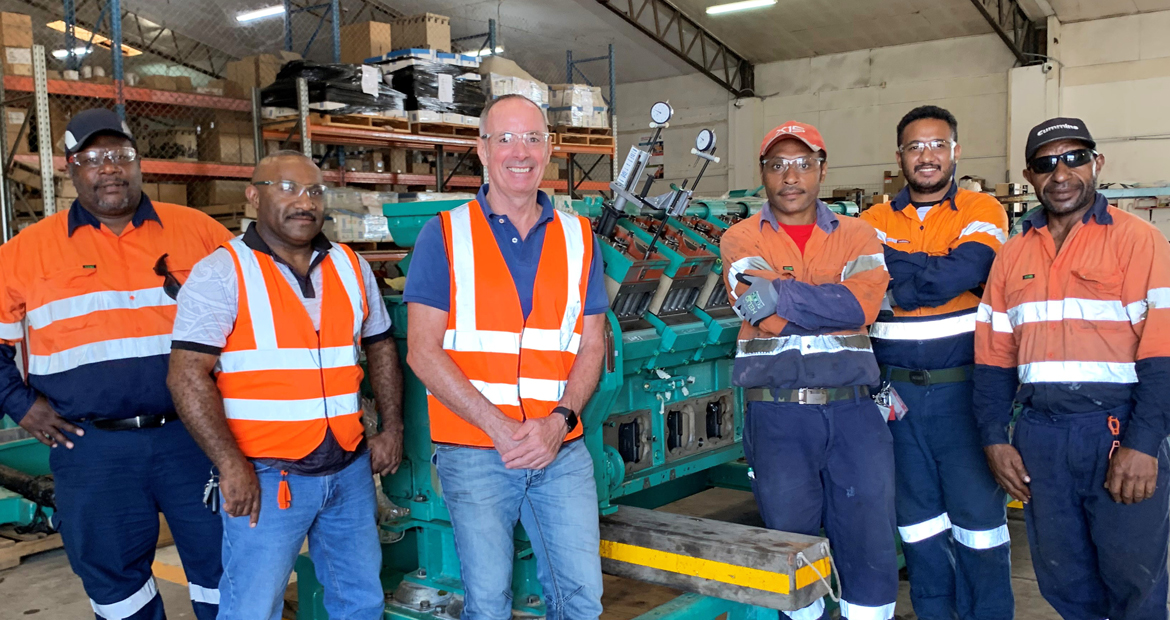 Cummins PNG general manager David Leach (centre) with Cummins technicians alongside an engine rebuild.
