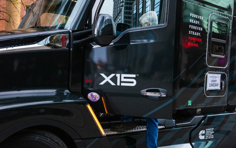 Man getting in drivers seat of Cummins X15 branded truck