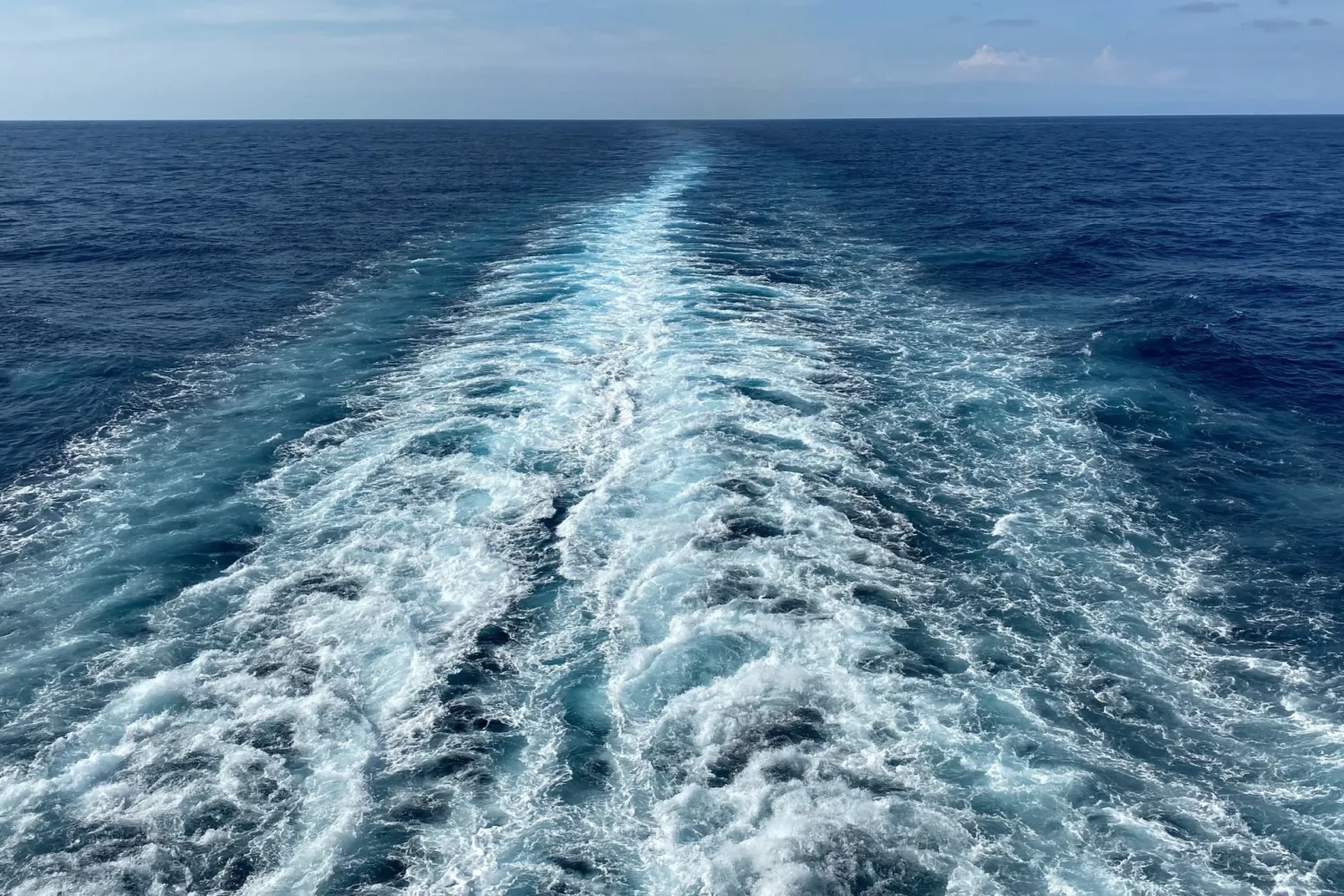 prop wash behind large boat in ocean