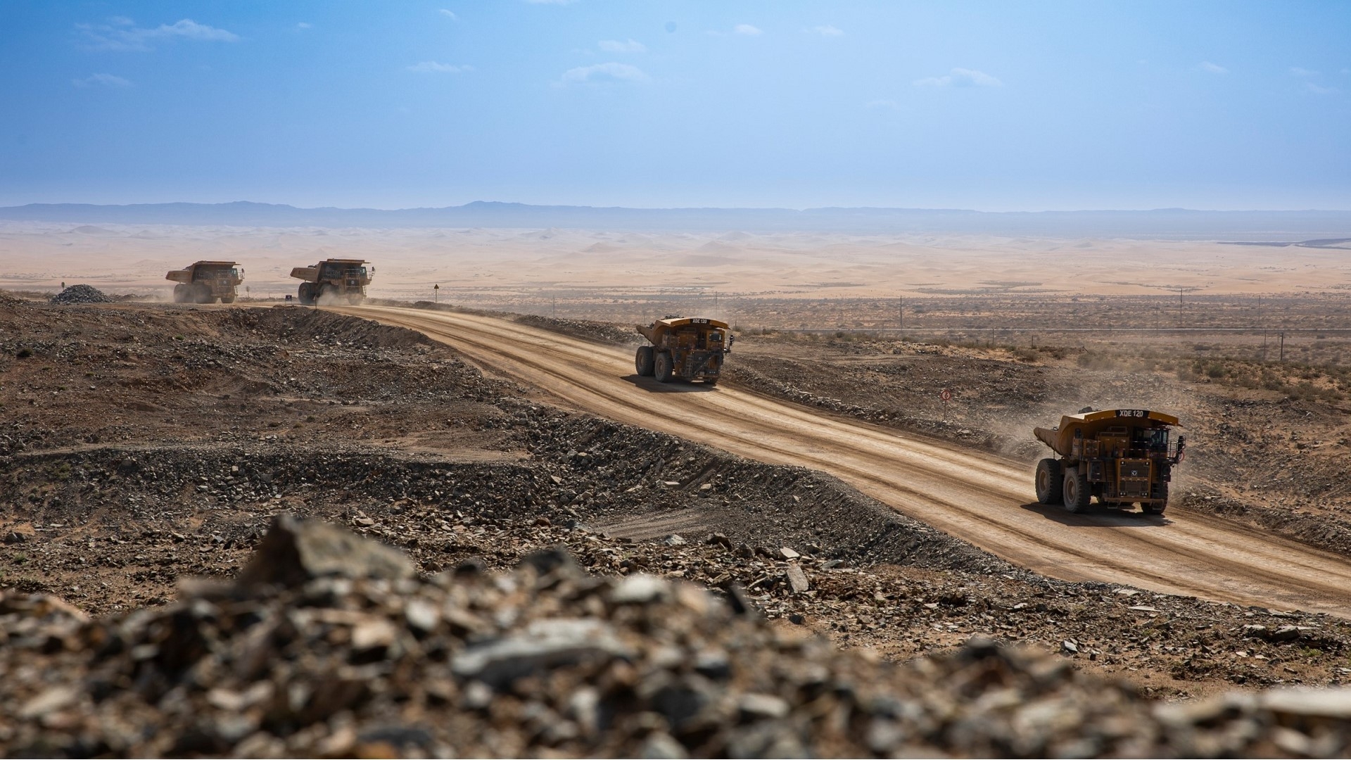 Large mining dump trucks on a dirt road