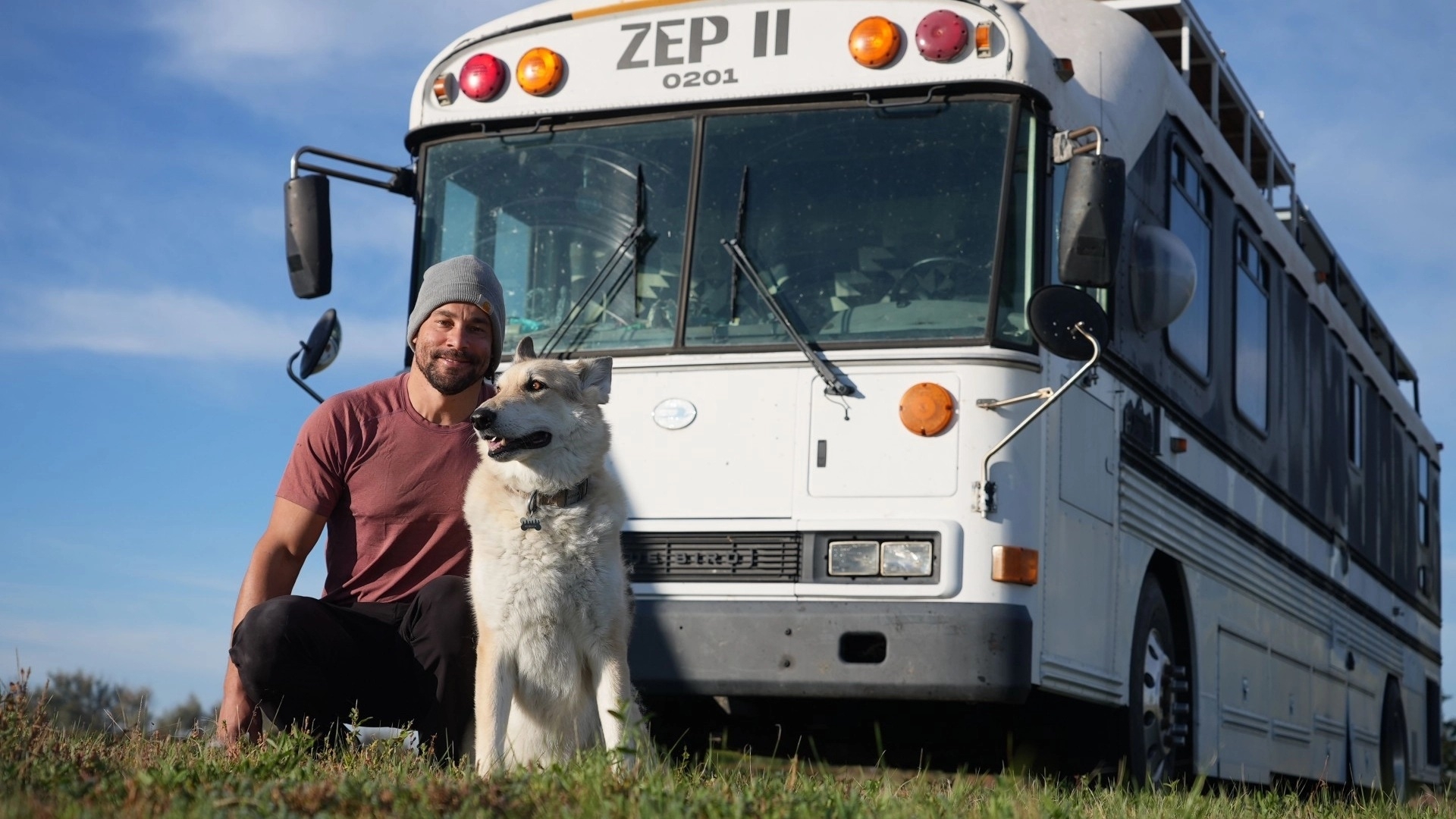 Man with his dog in front of a white bus