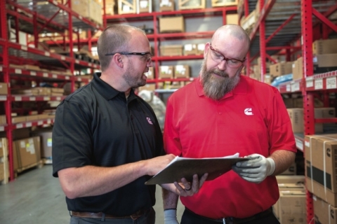 dealer and cummins representative look over inventory sheets