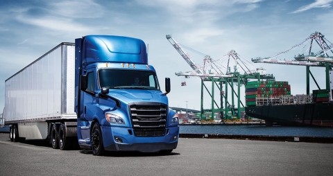 blue and white semi with a natural gas engine parked next to a body of water
