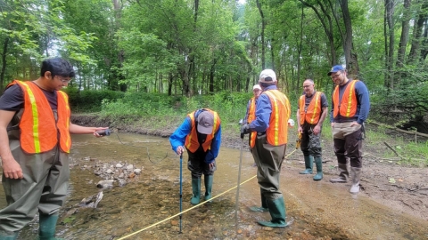 volunteers getting scientific readings in stream