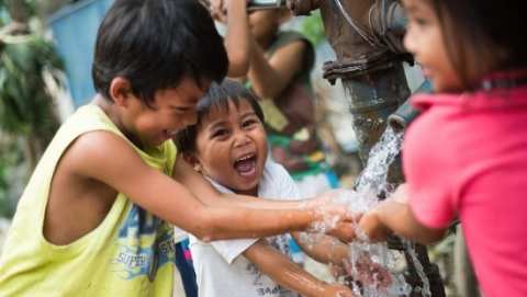 Kids washing their hands via a pipe