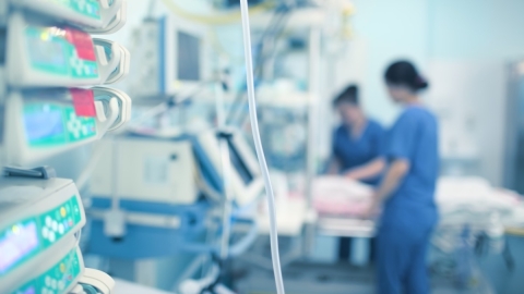 nurses working on patient in hospital room