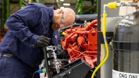 Tech providing maintenance to a Cummins engine