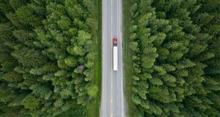 semi truck driving through forest