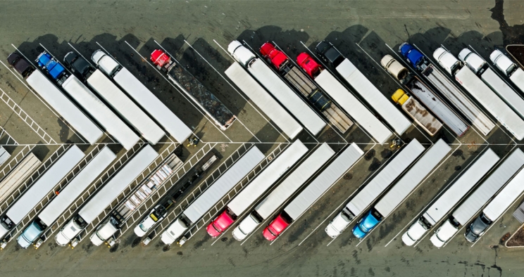 Heavy duty trucks parked diagonally in a parking lot