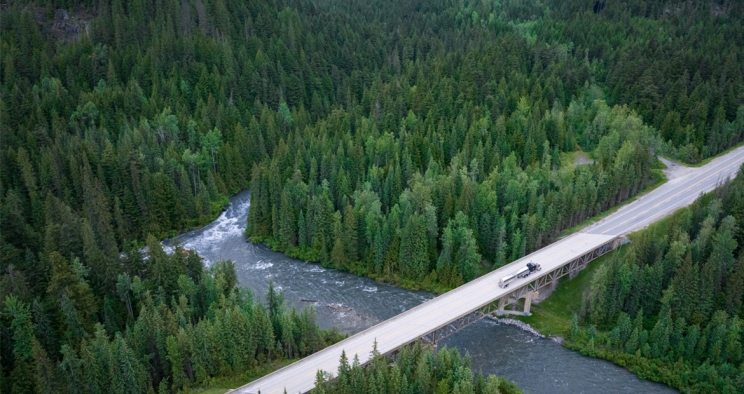 semi on a bridge around greenery