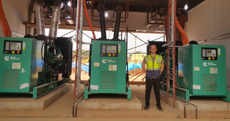 Adem Ersoy, Project Engineer at Cummins Turkey's authorized distributor Mepa Energy, stands next to the standby power system at Kigali Arena.