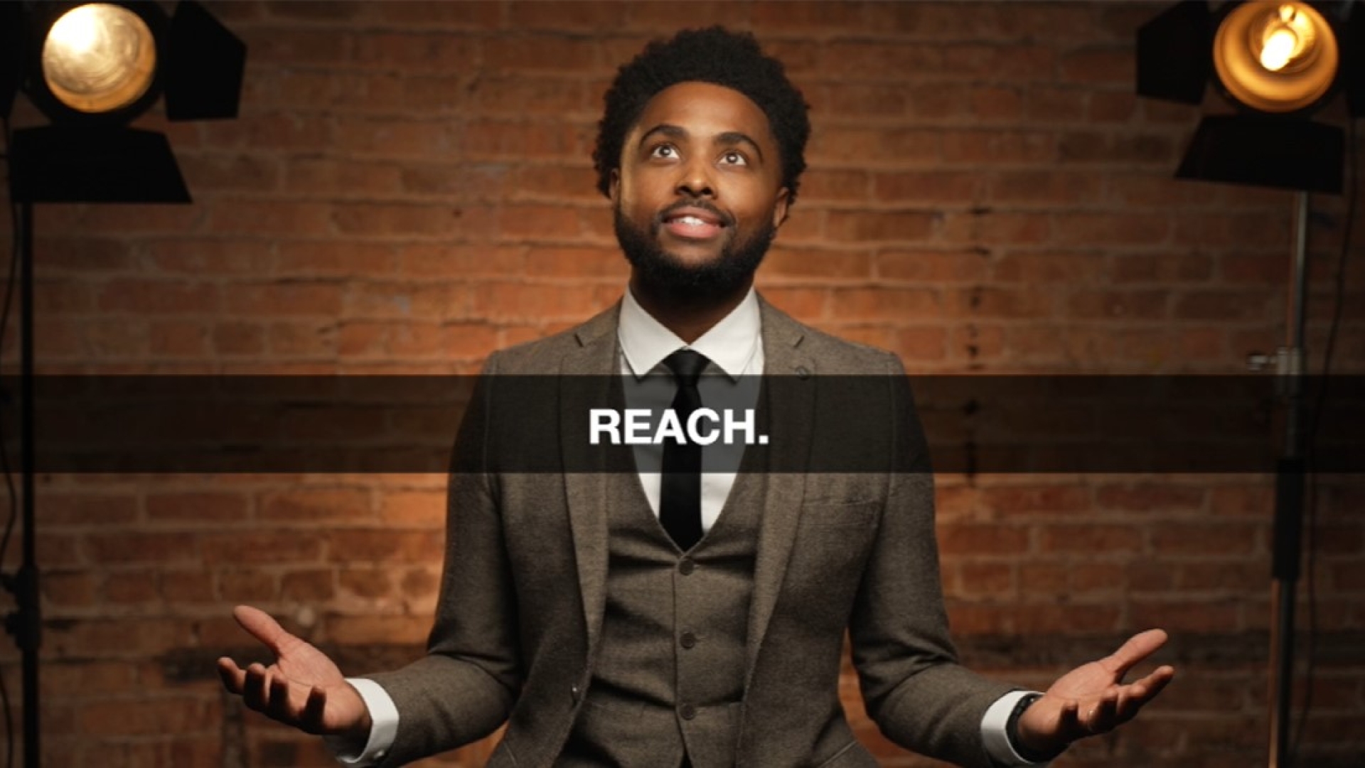 Derrick Christian sitting in front of a brick wall