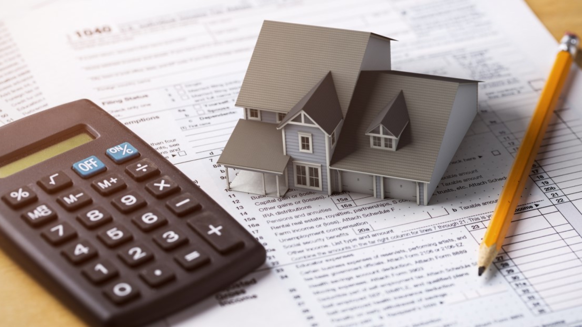 Calculator with small house on a table