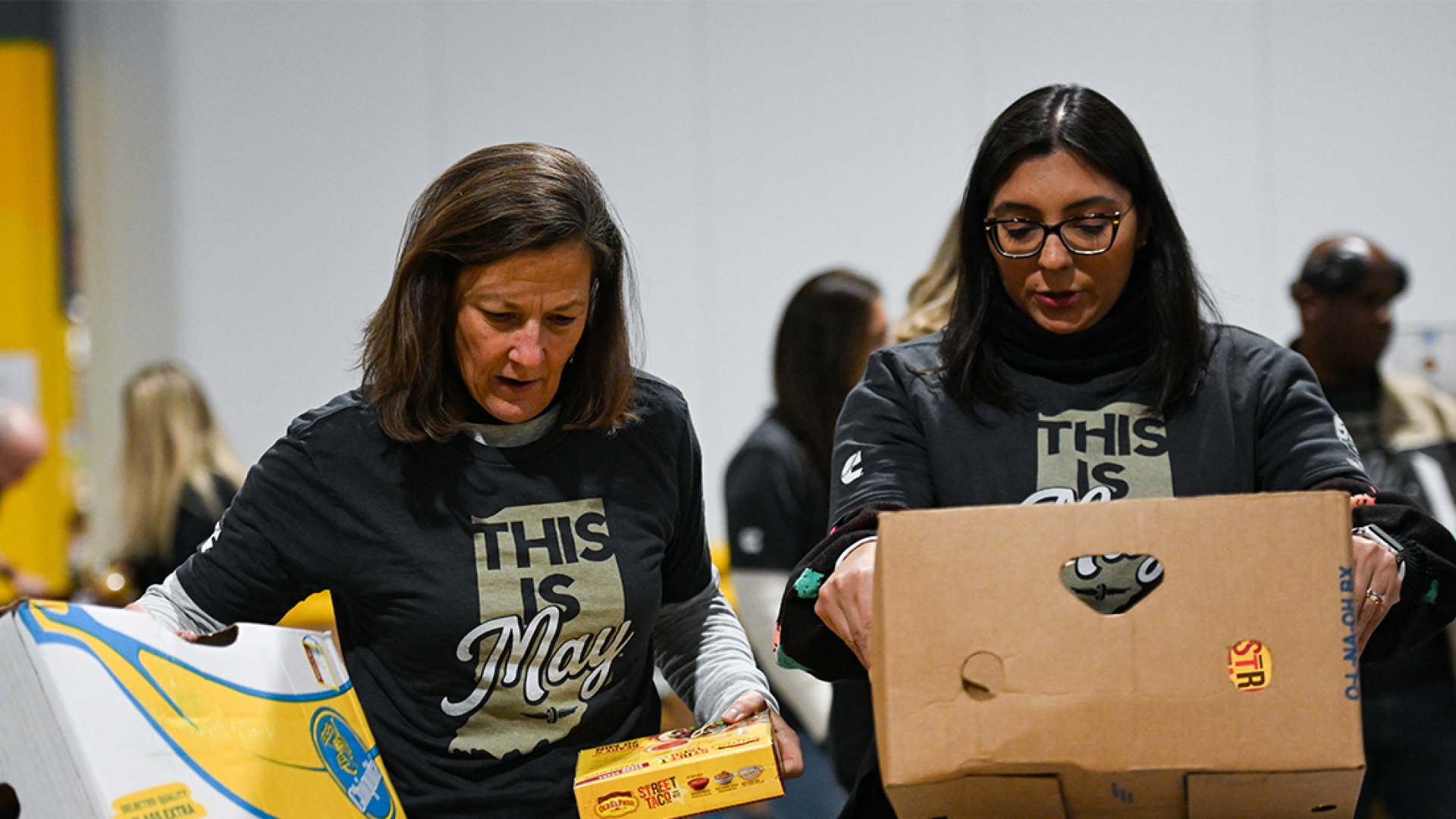 Cummins employees carrying boxes of food