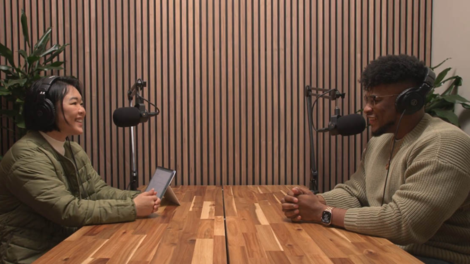 Podcast host and guest speaking into microphone