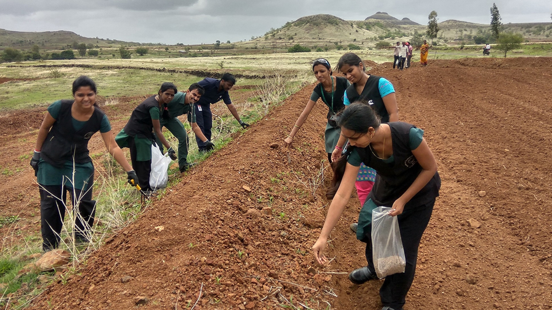 Cummins employees work on a grass-seeding project to help a community conserve water in India. This photo was taken prior to the COVID-19 pandemic.