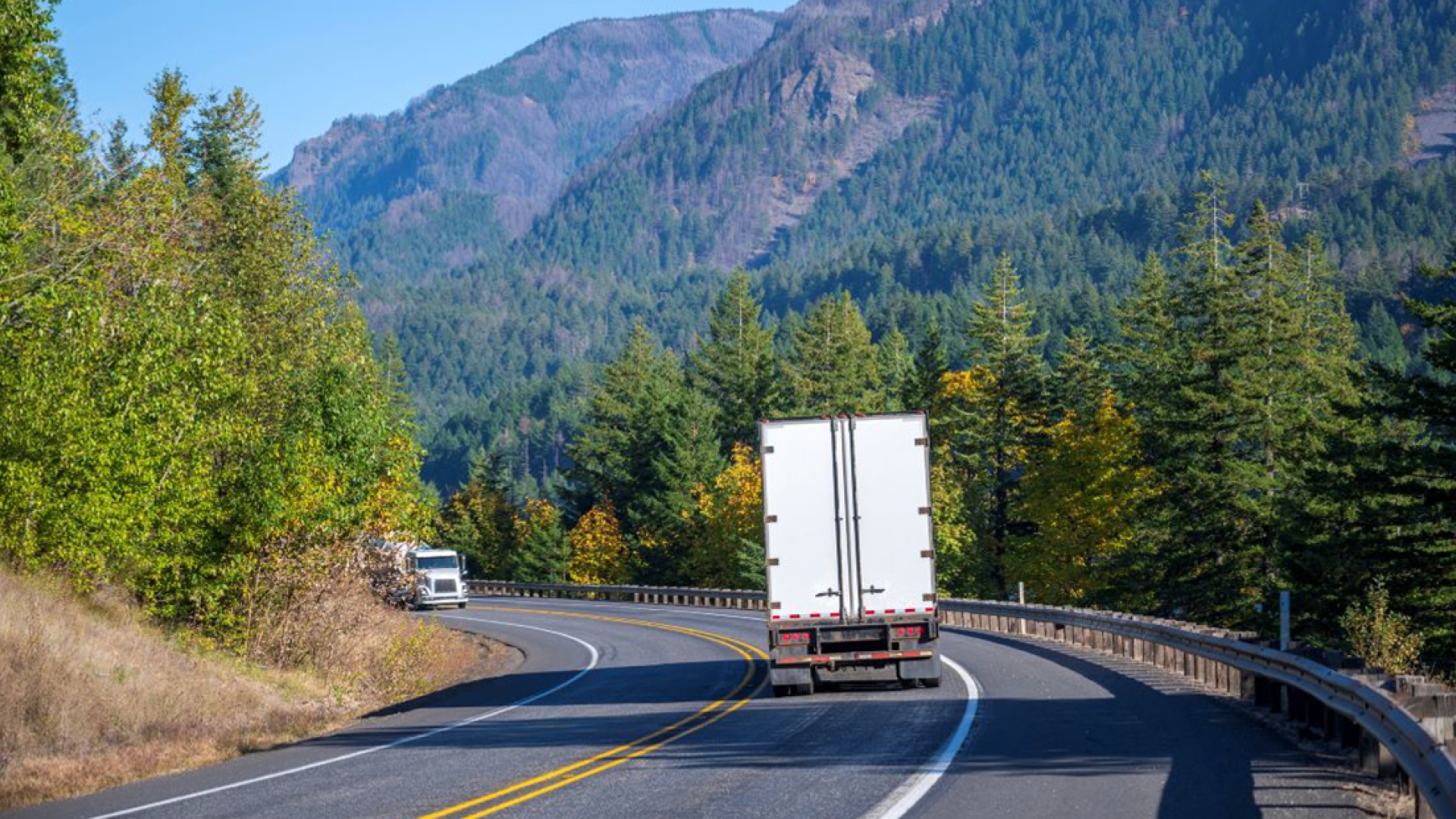 Semi driving on highway through mountains