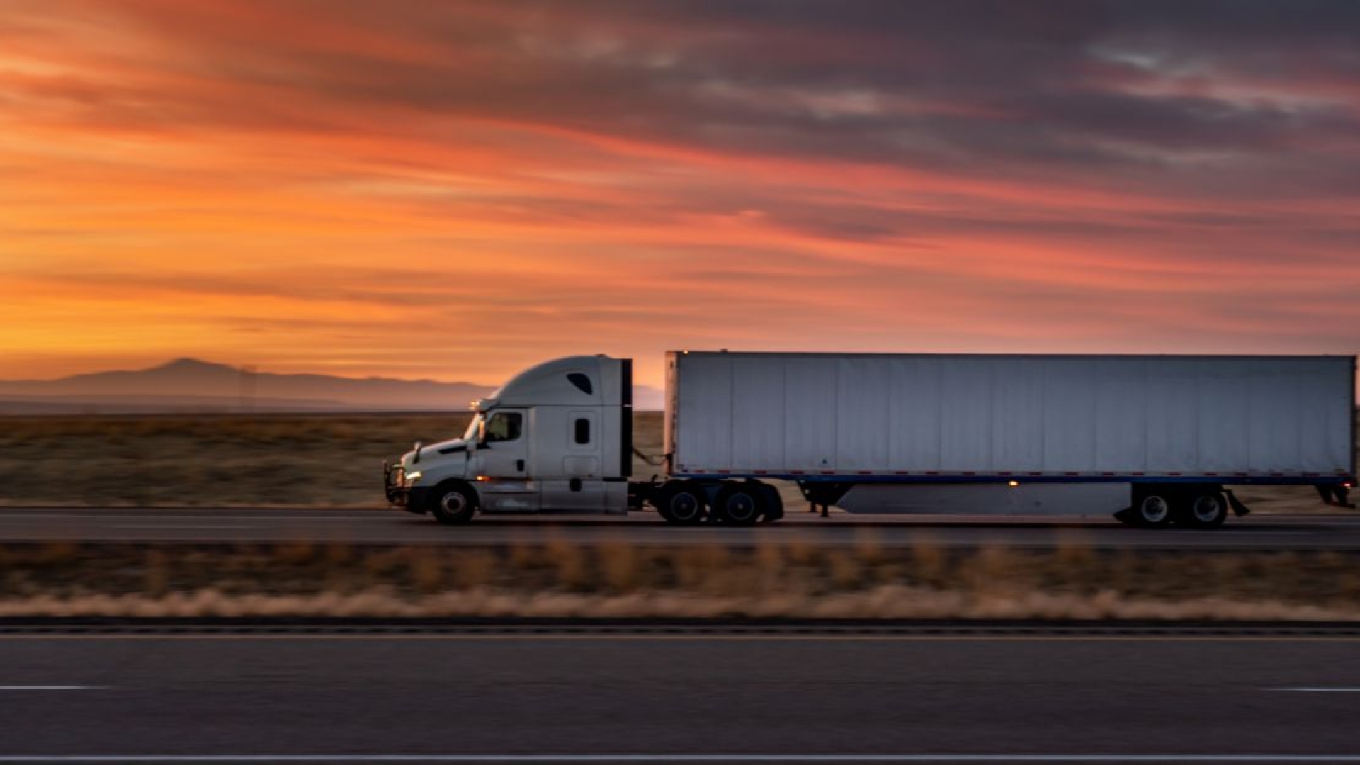 Semi truck on road with sunset