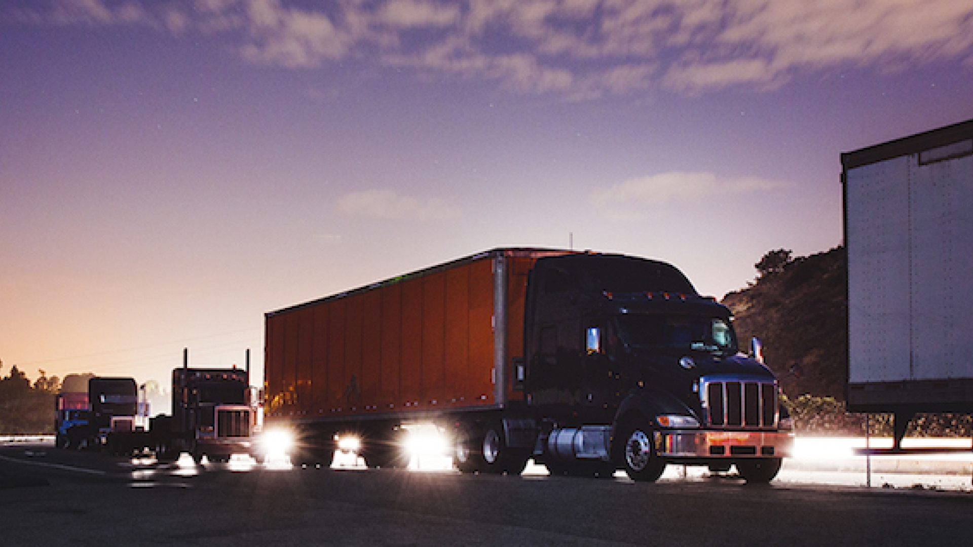 heavy duty truck fleet at sunrise