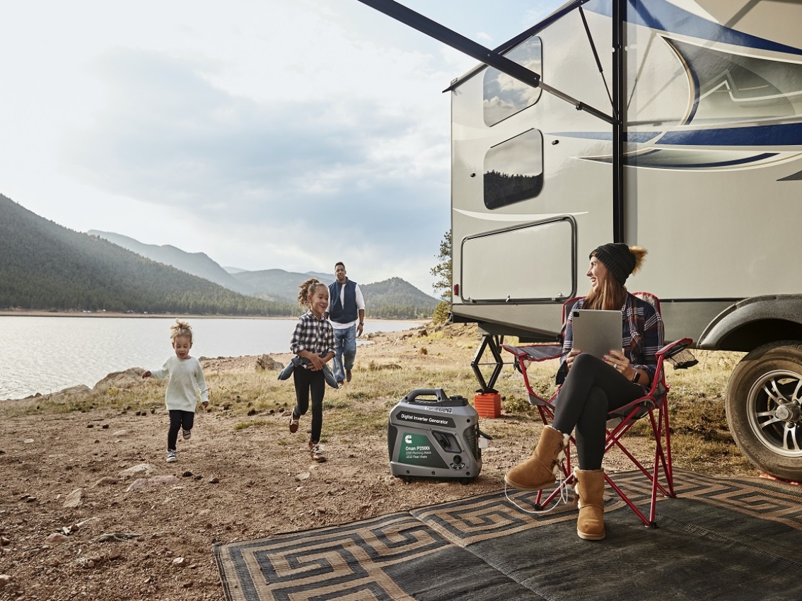 Family outside RV near body of water