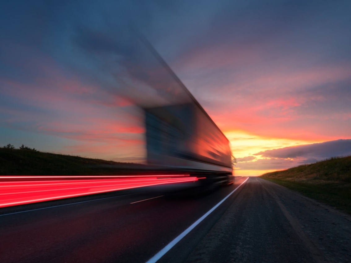truck moving towards the sun setting