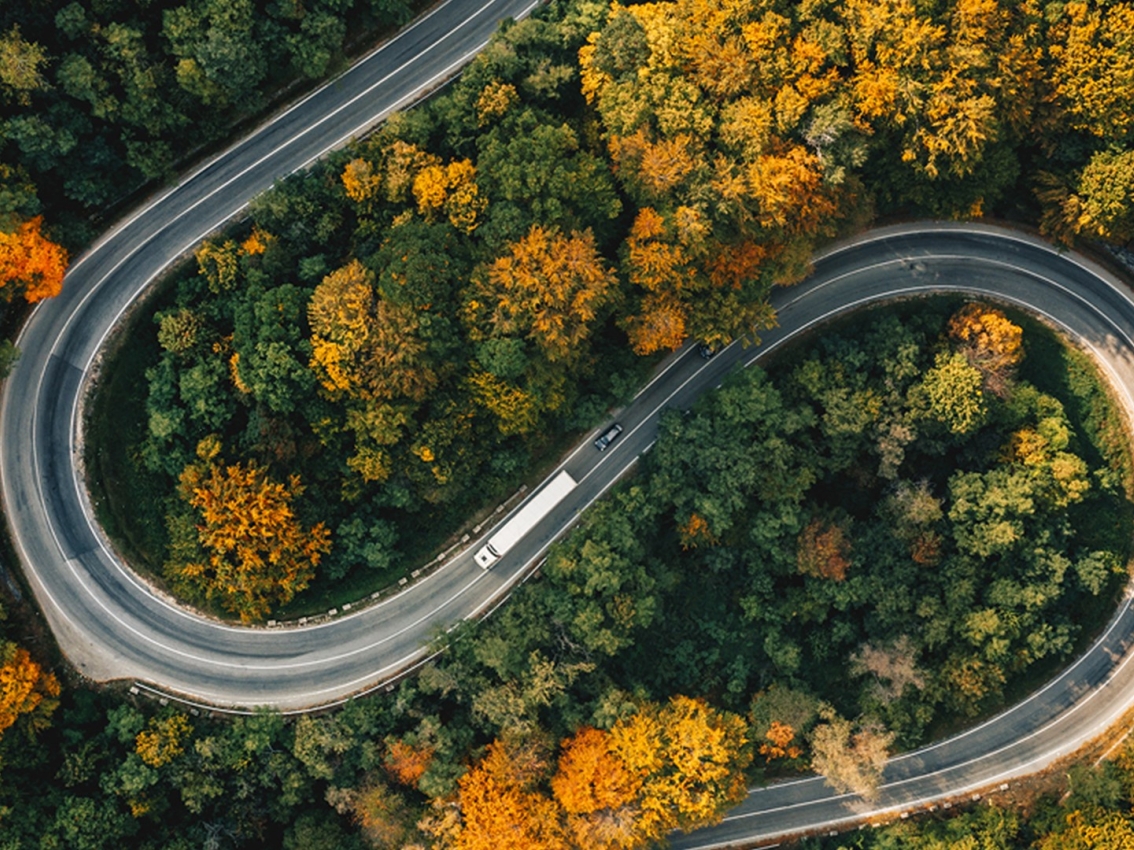 Truck driving up a curved road up a hill