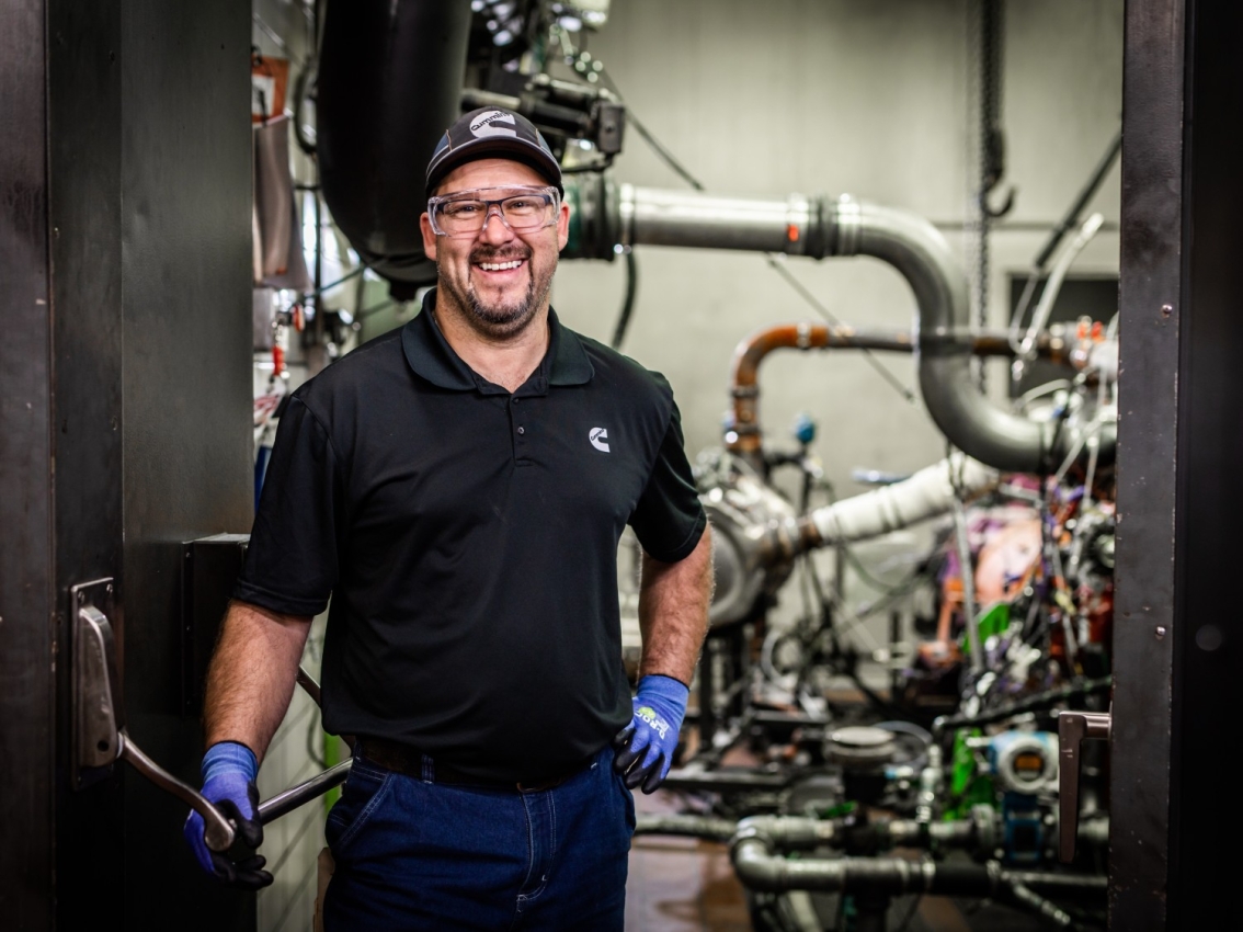 technician posing in generator room