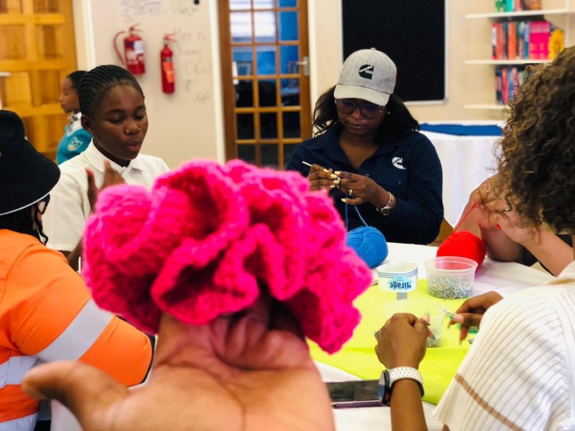 Holding up a scrunchie as people work