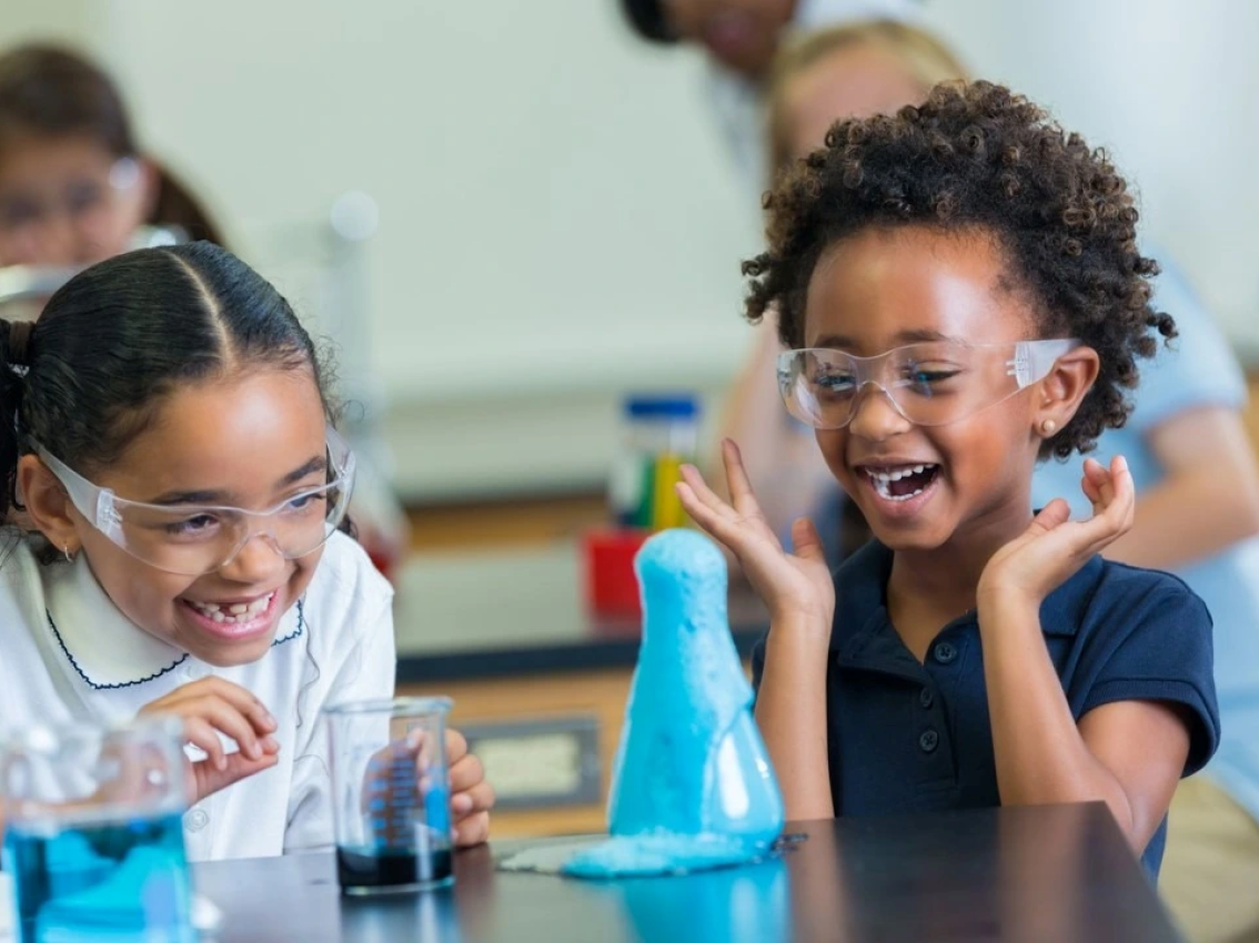 two students at desk with science experiment