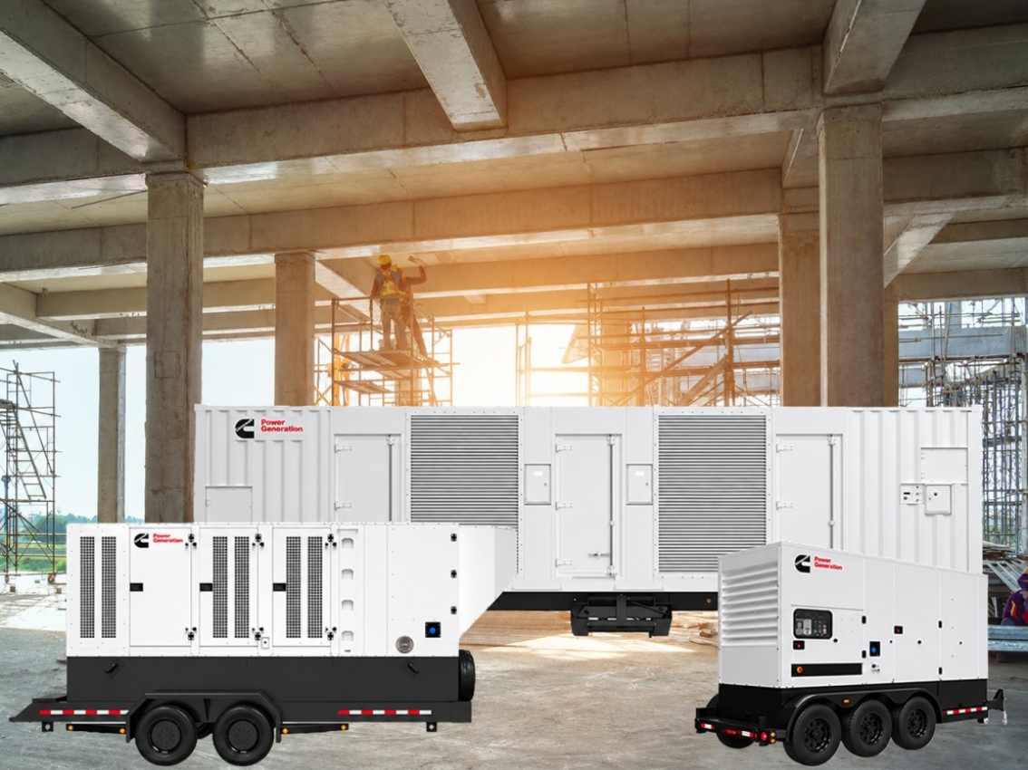 Cummins portable generators and a power enclosure at an active construction site with scaffolding overhead