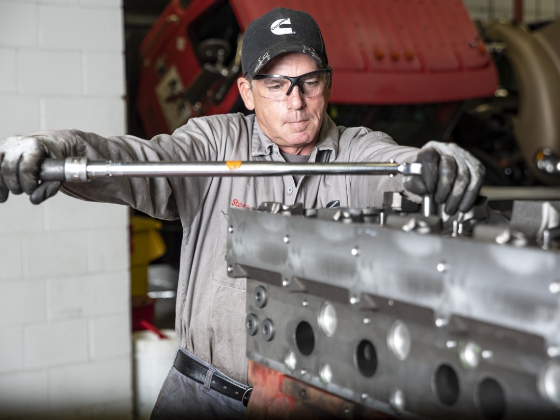 Technician assembling a large Cummins engine component